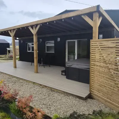 Covered deck with private hot tub at the Spacious Family Lodge
